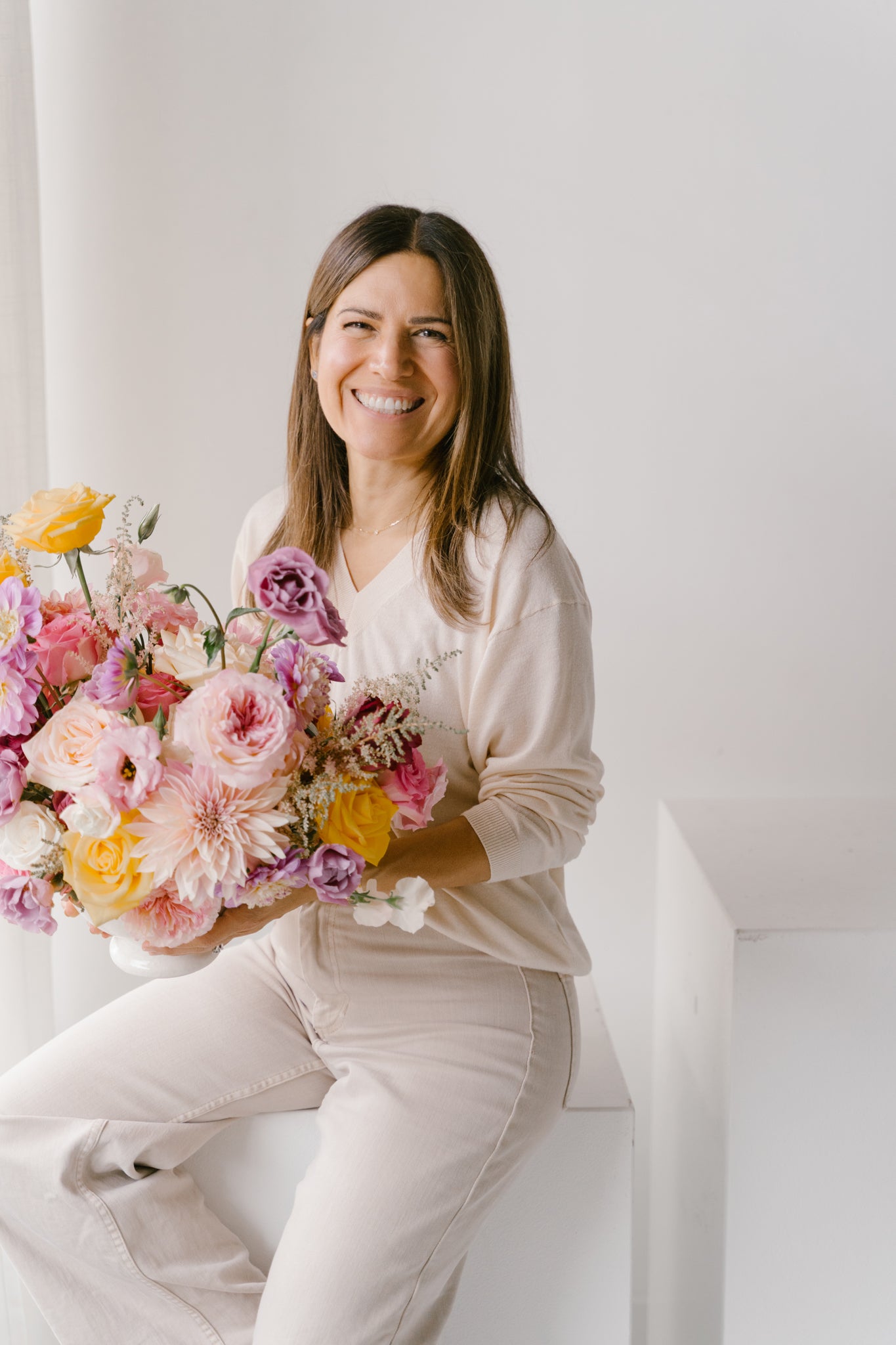 Portrait of Regina Rivera, founder of Blossom Grid, holding a bouquet of flowers.