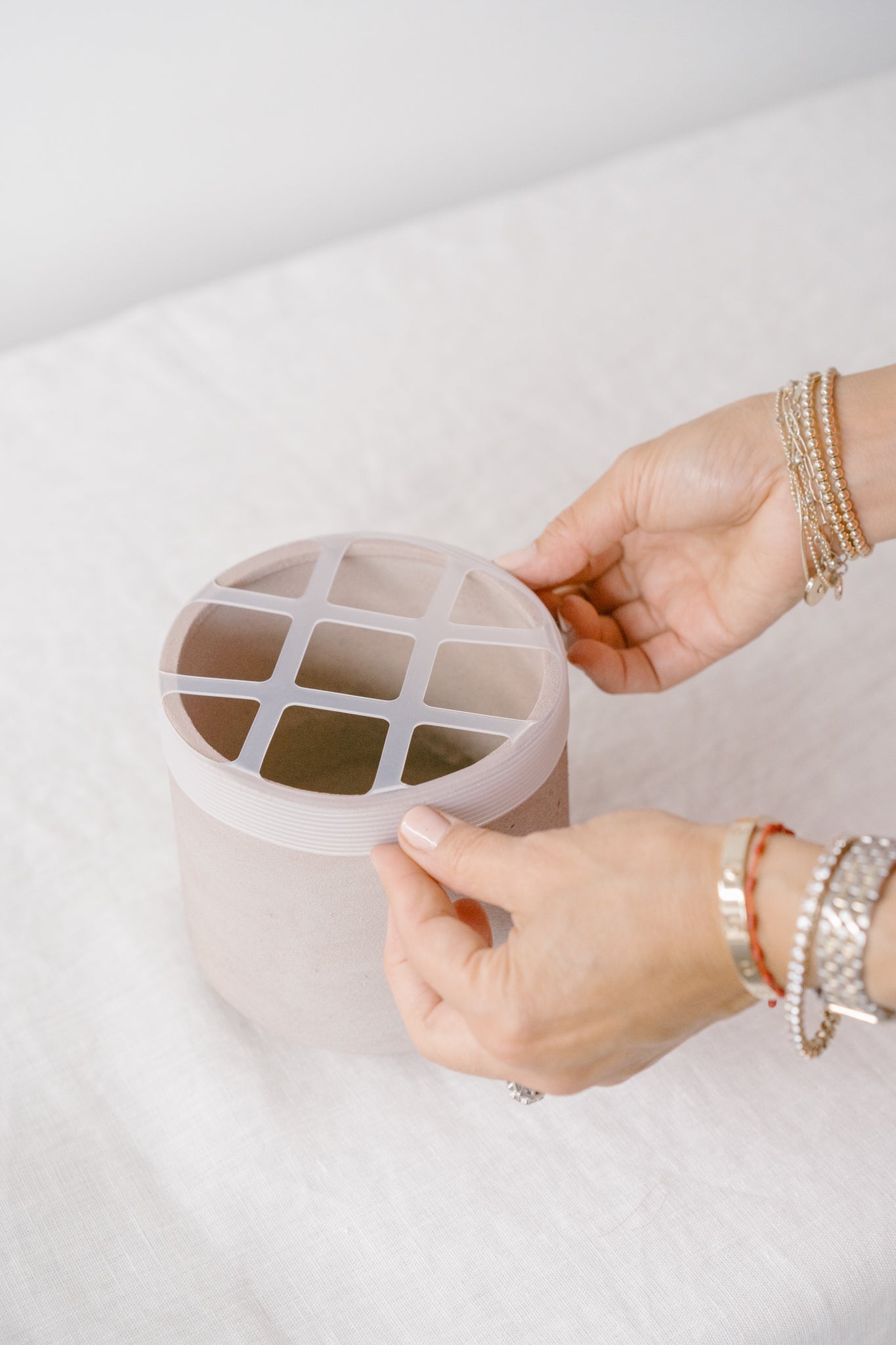 Step 1 with a person holding the Blossom Grid wrapped over edges of a vase.